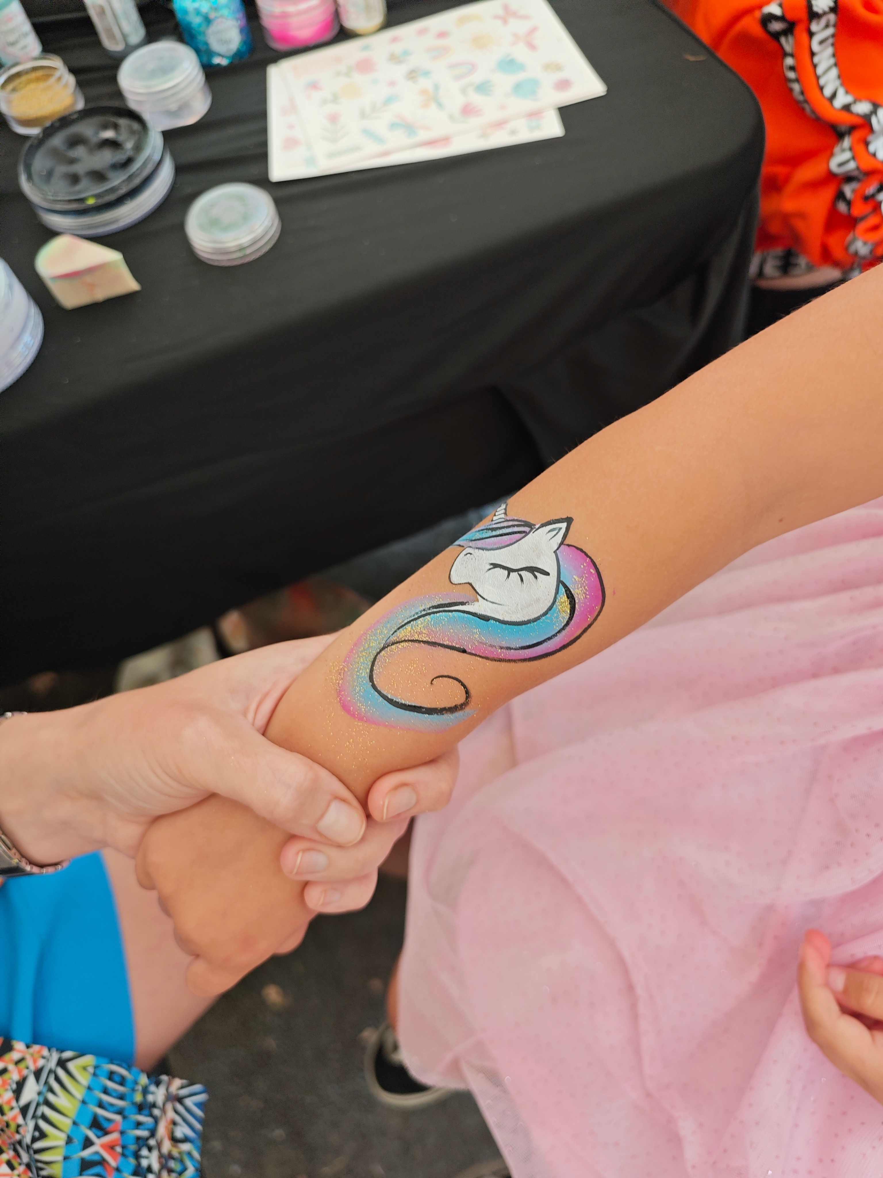 Einhorn mit Regenbogenmähne auf den Arm geschminkt – Kinderschminken Fulda